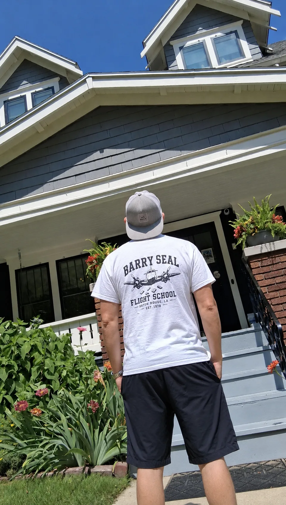 White Barry Seal Flight School tee worn outdoors, showing the Baton Rouge back graphic